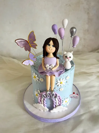 A sweet cake for a little girl who loves her pet cat and the color purple. It features a custom sugar figurine of the birthday girl with her kitten.