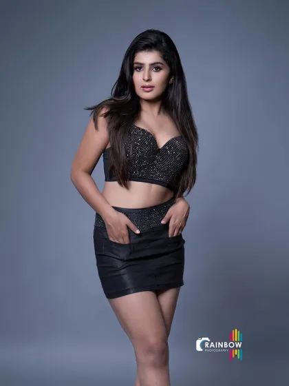 A full-body shot in a black sequined outfit, conveying confidence and style.