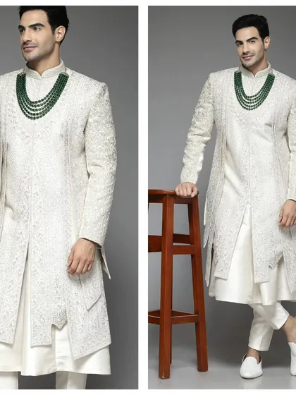 Another angle of a white layered sherwani, this time paired with a green beaded necklace. Our pre-loved collection allows for versatile styling.