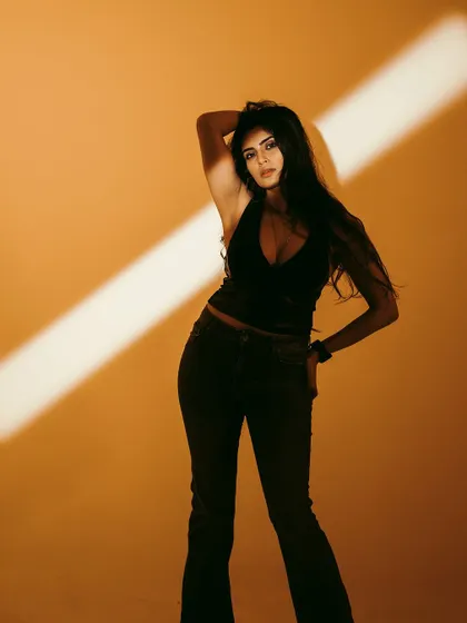 A powerful and confident pose, using the single light source to sculpt the body and create a strong silhouette.