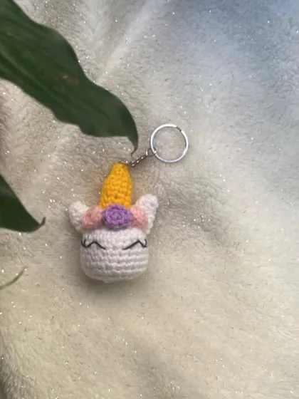 A custom-made unicorn head keychain. The horn is a bright, cheerful yellow, and it has a little flower in its mane. It's a small piece of magic you can carry with you.