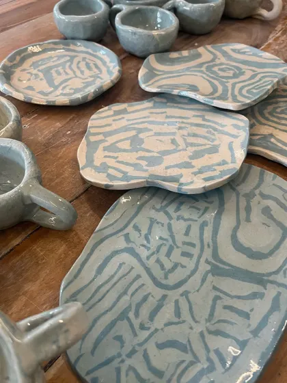 A collection of beautiful plates and cups made using the Japanese Nerikomi technique. Each piece has a unique marbled pattern created by layering colored clays.