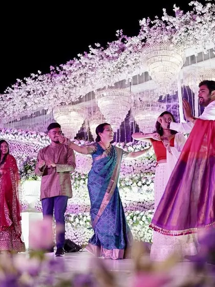 Guests enjoying a dance at a reception, with the beautiful floral and light decor creating a magical atmosphere.