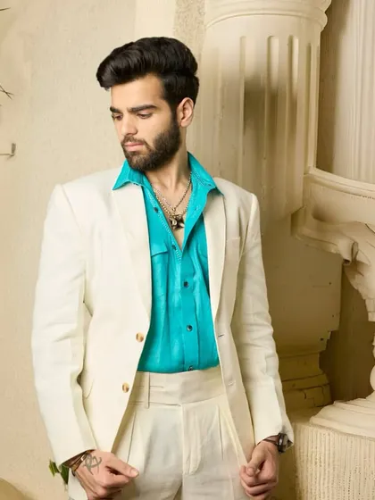 The off-white suit, paired with a bright turquoise shirt, creates a look that is both fun and refined, perfect for making a statement at any party or social gathering.
