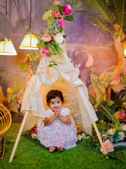 A full view of our enchanted forest teepee setup. This theme includes a lace teepee, a wicker chair, a glowing lamppost, and a lush forest backdrop for a magical camping adventure.