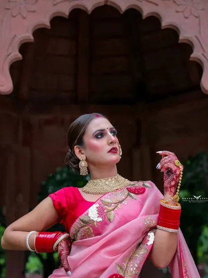 A powerful portrait where the model looks up with a strong expression. The pose highlights her traditional gold jewellery and the bold red bindi.