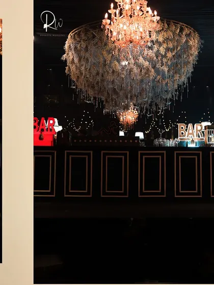 A floral chandelier and a custom bar front, demonstrating how I carry a design theme across different elements of an event.