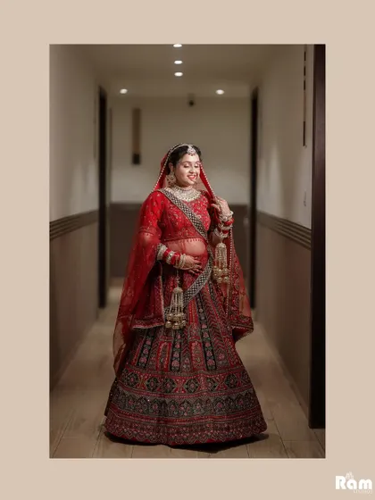 A beautiful full-length portrait of the bride in a hallway, her red lehenga and gentle smile creating a picture of grace.