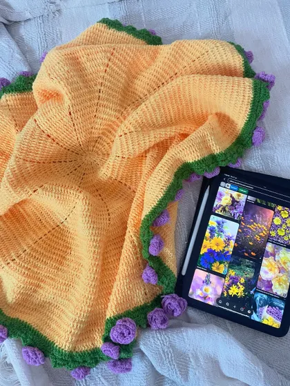 The bouquet blanket, spread open to show its full size. The intricate crochet work and floral border are on full display.
