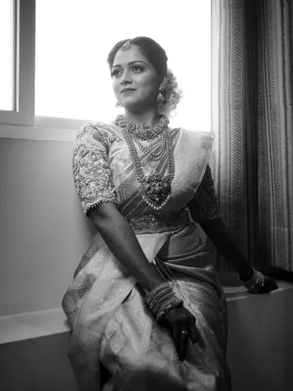 A black and white version of a bride's portrait by the window, adding a timeless and dramatic feel.