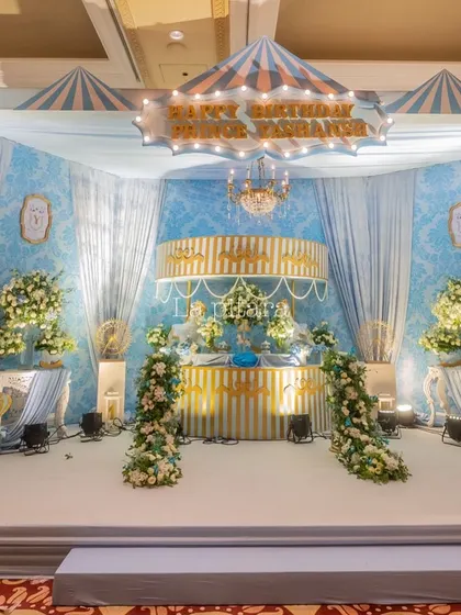 A wider shot of the carousel stage, showing the full setup with flanking carousel horses and beautiful floral arrangements. The design transformed the ballroom into a whimsical fairground.