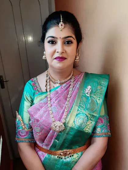 All set for her housewarming function. I created a sophisticated look with a bold lip and defined eyes that beautifully complemented her pink and green silk saree.