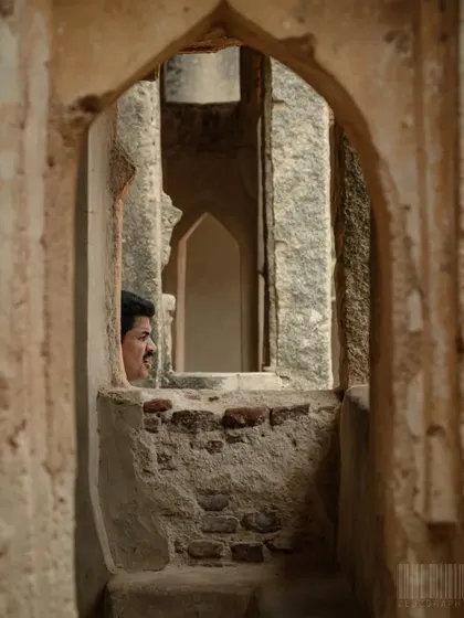 A person peeking through a window within a window in Hampi's ruins. This "frame within a frame" composition is a creative technique I use to make images more interesting.
