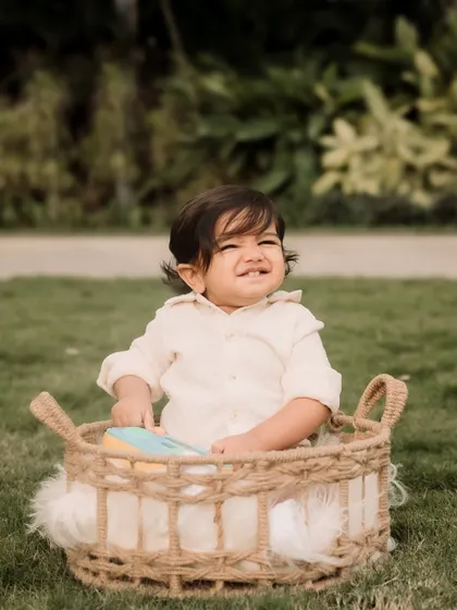 This little one's cheesy grin from inside a woven basket is just priceless.