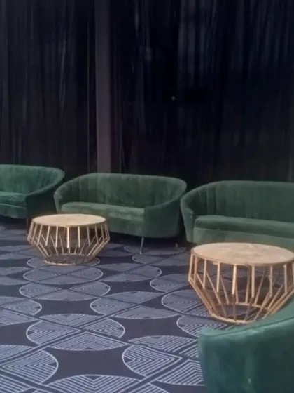 For a modern cocktail or sangeet night, I offer stylish furniture like these emerald green velvet sofas. Paired with geometric gold coffee tables, they create a sophisticated and trendy lounge.