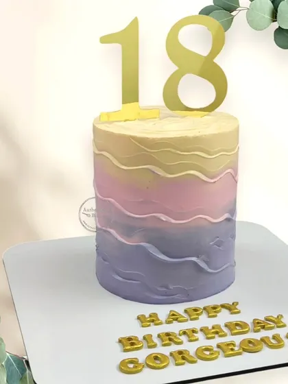 A colorful cake for a "gorgeous" 18th birthday. The wavy, multi-colored frosting creates a fun and vibrant look for this special milestone.
