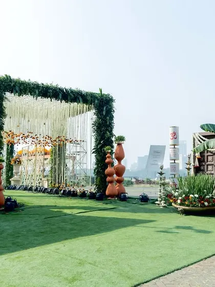 A wider view of the grand floral entrance, showing how the green archway and traditional elements create a stunning visual path against the open sky, perfect for a large-scale outdoor wedding.