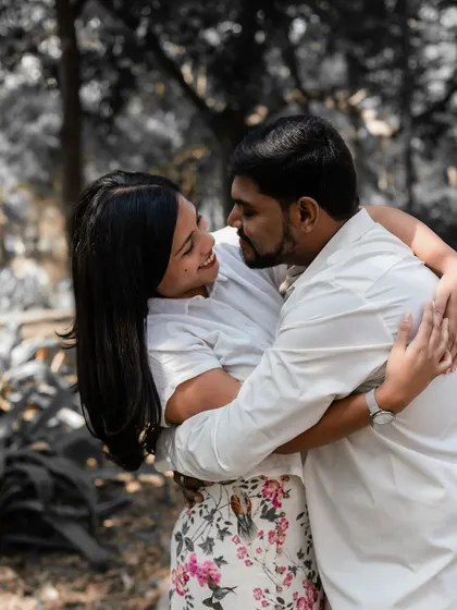 A warm, loving hug shared between the couple, with a black and white background that makes their connection the central focus.