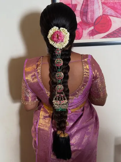 The complete look, showing how the heavily accessorized braid complements the beautiful silk saree. This is a perfect example of a grand, traditional hairstyle for a special occasion.
