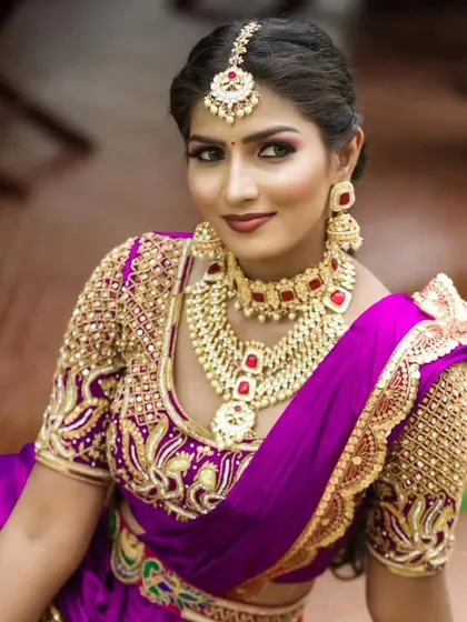 A stunning bride wearing a heavy Kundan necklace set with red stones. This is a perfect choice for a grand bridal look.