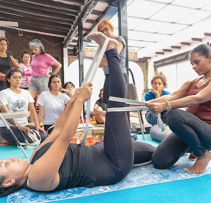 Teaching is a process of mutual learning. During a workshop in Bogota, Colombia, I guide a student in Supta Padangusthasana using a strap. This hands-on adjustment helps her find greater length and stability, showcasing the personalized and supportive nature of my sessions, no matter where in the world we practice.