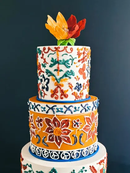 A close-up of the top two tiers of the Rangoli cake, highlighting the incredible, colorful patterns.