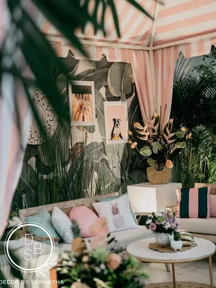 A closer look at the cozy seating area inside the cabana. The mix of textures, from the plush cushions to the leafy wallpaper, created a rich and inviting space.