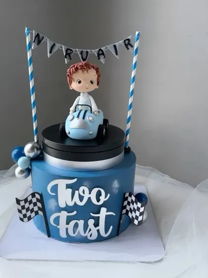A moving top cake for a "Two Fast" birthday. The little blue car on top actually rotates, adding a fun, kinetic element to the celebration.