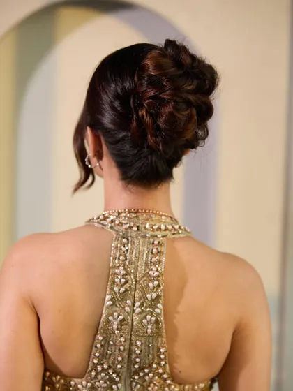 A back view of the textured high bun, showing the intricate twists and loops that create its volume and shape. This is a popular style that you will master in my hands-on sessions.