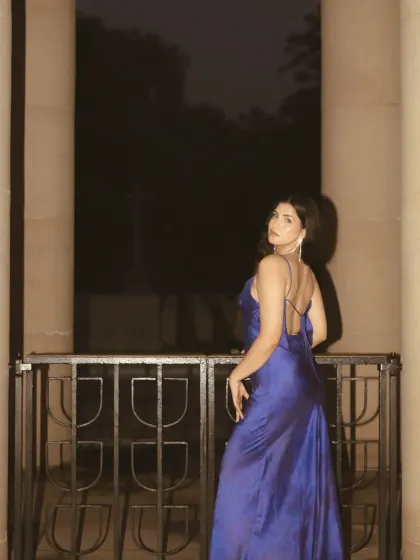 Another night shot from the pillar location, with the subject looking back at the camera. The direct flash creates a bold, fashion-forward look against the darkness.