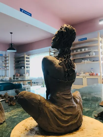 A back view of the "Naughty Girl" sculpture, showcasing the incredible detail in the hair and the musculature of the back.