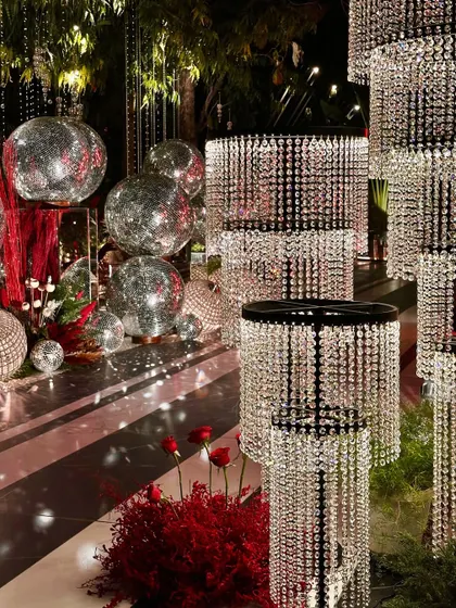 A glamorous photo corner with crystal chandeliers and silver disco balls, perfect for a glitzy cocktail night.