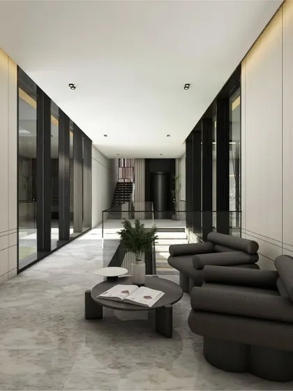 A modern hallway where expansive glazing and polished marble flooring create a sense of timeless elegance. The restrained palette of grey seating, wood paneling, and black-framed glass doors composes a refined narrative of contemporary luxury.