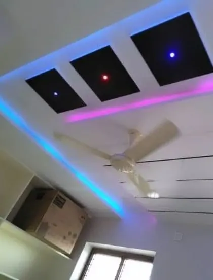A minimalist design with a twist. The three black panels have small colored lights, while the cove lighting uses blue and pink for a modern glow.