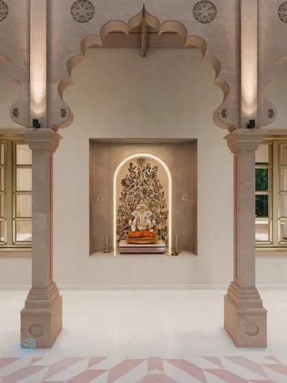 A dedicated puja space is framed by traditional carved stone pillars. The serene niche features soft, integrated lighting that highlights the Ganesha idol, creating a tranquil and spiritual corner within the home.