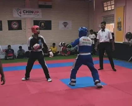 A wide view of the competition mat, where two fighters maintain their distance, looking for an opening. Tactical awareness is a key skill we teach.