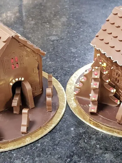 A closer look at two of my chocolate Christmas huts, highlighting the fine details like the doorway arches and the texture of the chocolate walls.