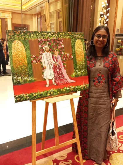 Standing proudly with my completed artwork on its easel at a Delhi wedding. The painting is ready to be presented to the couple as a permanent reminder of their celebration.