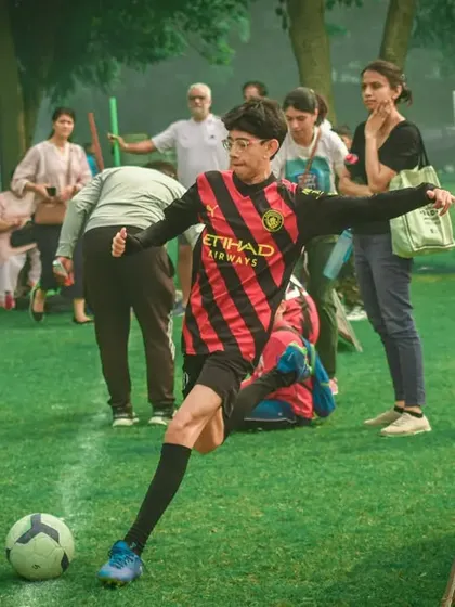 A player takes a shot with parents watching in the background.