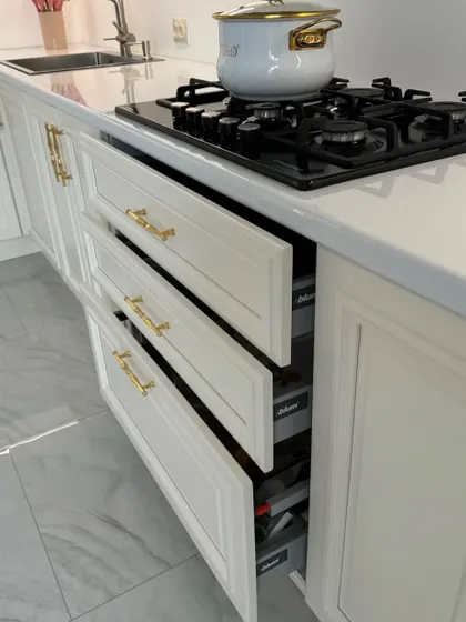 Our classic kitchens feature premium hardware. Here you can see a set of smoothly operating drawers with elegant gold handles, providing ample and organized storage.