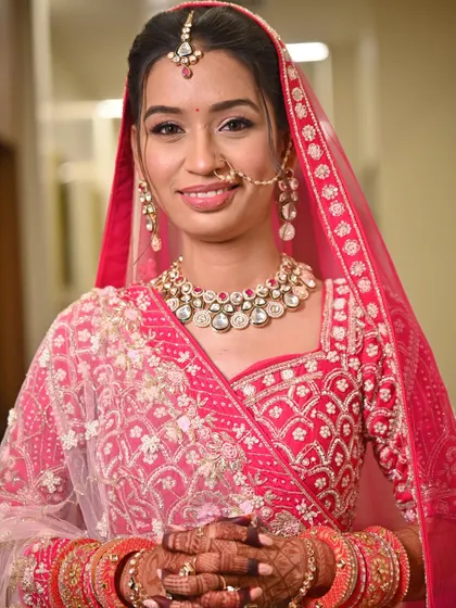 A close-up of this bride's flawless look for her big day. The makeup was kept soft and radiant to complement her bright pink lehenga, complete with a delicate nath and maang tikka.