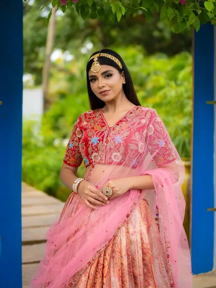 A closer portrait in the same ensemble, focusing on the bride's expression and the detailed embroidery of the blouse.