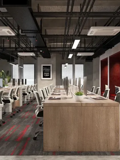 The open-plan workstation area at Mahalakshmi Logistics, featuring an industrial design with exposed ceilings and ducting. We incorporated dedicated privacy pods with red acoustic paneling for quiet work or calls.