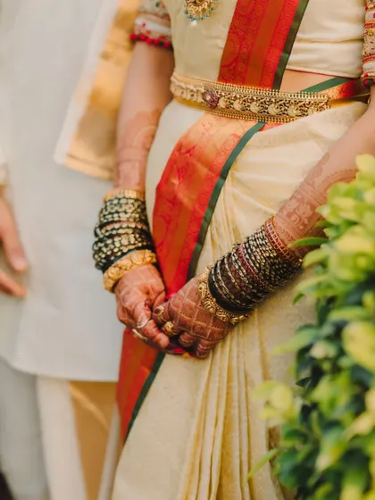 A detailed shot of the bride's hands, adorned with beautiful henna and traditional green and black bangles.