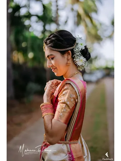 A side profile showcasing Sharvari's elegant bridal bun adorned with fresh flowers.
