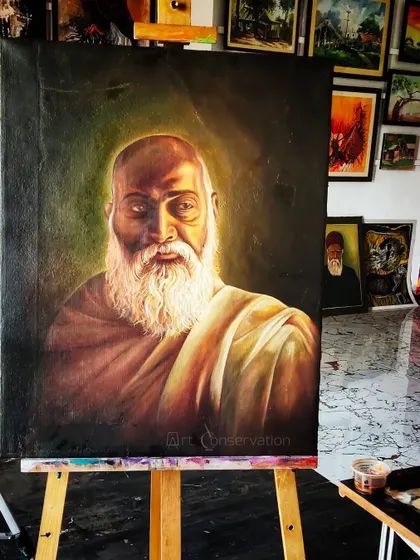 A completed portrait restoration of a spiritual figure, now resting on an easel in my studio. The lighting highlights the restored textures in the beard and cloth, ready to be returned to the client.