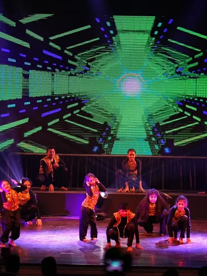 The kids hitting the floor for a synchronized ground move, showing the versatility and athleticism in their hip hop routine.