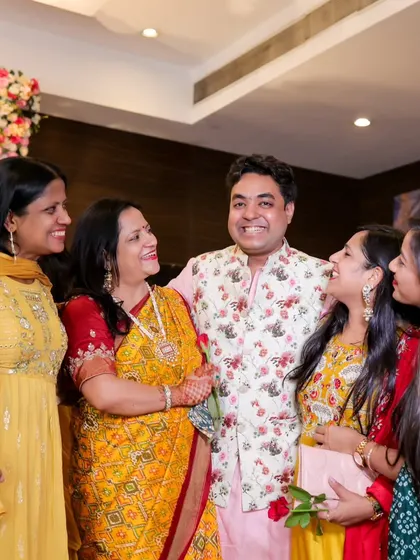 A beautiful, candid photo of a man surrounded by the smiling women of his family. It's a moment of shared laughter and connection.