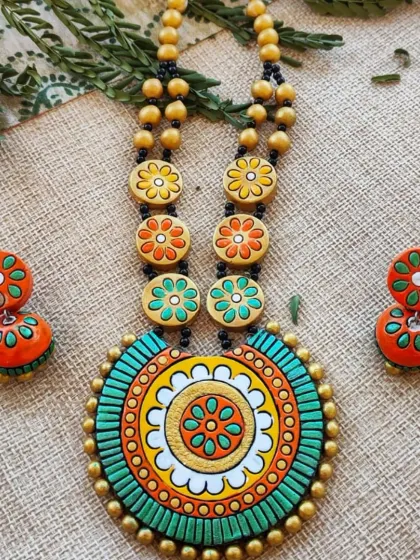 A green and orange colorway for the floral mandala necklace. The earthy tones make it a versatile piece that can be paired with many traditional outfits.