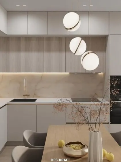 A minimalist kitchen with handleless cabinetry, a marble backsplash, and striking globe pendant lights. The design is clean, uncluttered, and effortlessly sophisticated.
